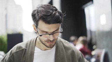 Et açık bir kafede yemek gözlüklü hipster adam