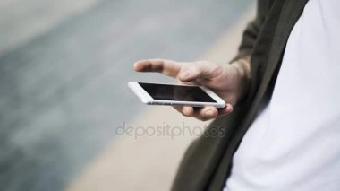 Bir sokakta bir akıllı telefon ile bir adamın elini