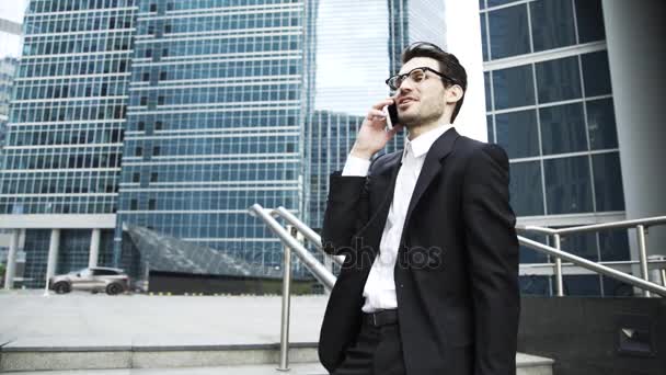 Jeune homme d'affaires parlant sur un téléphone dans un escalier à l'extérieur — Video