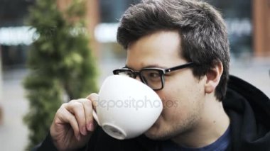 Kahve içiyorsun gözlüklü bir adam, yakın arkadaş için dinleme ve gülüyor