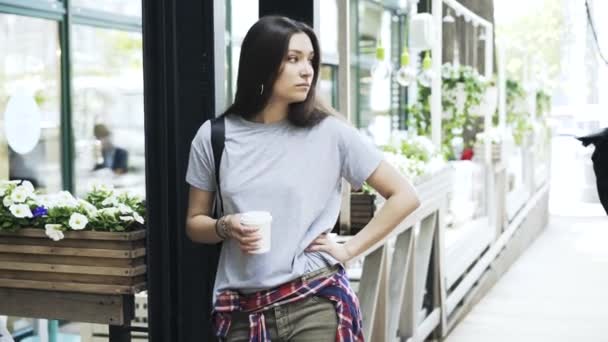 Hermosa joven bebiendo un café para ir mientras espera — Vídeos de Stock