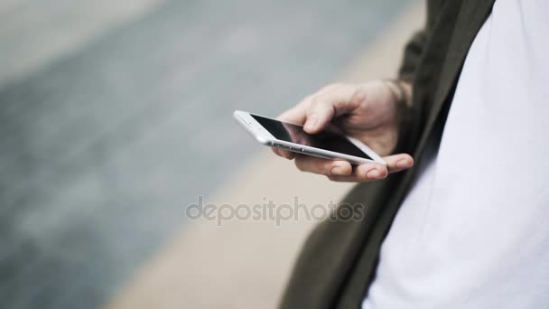 Fechar a mão do homem com um smartphone deslizando e ampliando em — Vídeo de Stock