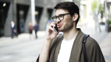 Telefonda konuşurken ve dışında gülüyor gözlüklü bir hipster adam, yakın çekim