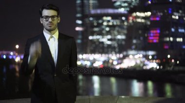 Gözlüklerini koyarak ve bir cityscape geceleri arıyorum genç işadamı
