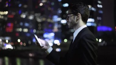 Bir işadamı web gökdelenler arka plan sörf, yan görünüm