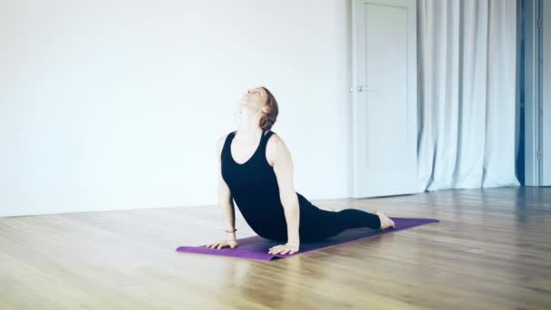 Mooie witte vrouw doet yoga binnen, zijaanzicht — Stockvideo