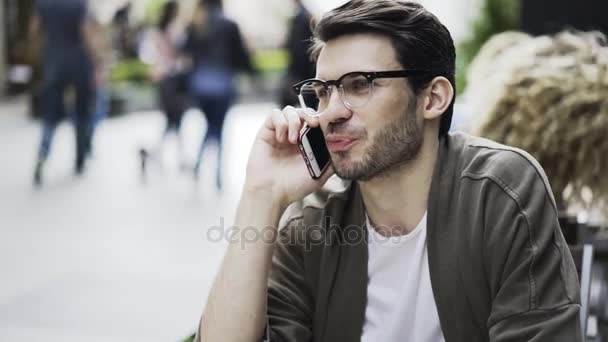 Young hipster in a cafe on the phone, close up — 图库视频影像