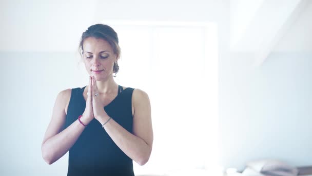 Primer plano de una hermosa mujer de mediana edad en negro meditando — Vídeos de Stock