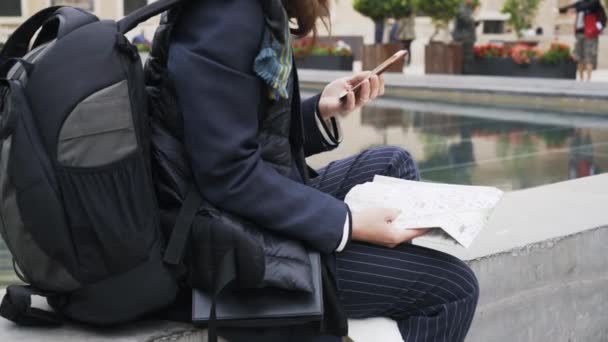 Vista lateral de una joven turista con smartphone y mapa en Valencia — Vídeo de stock