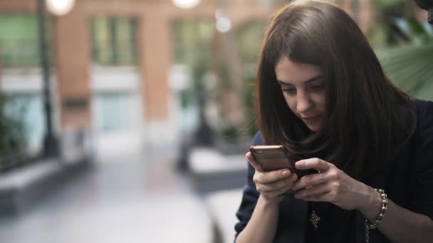 Primer plano de una hermosa joven con teléfono en el Jardín Botánico de Madrid — Vídeos de Stock