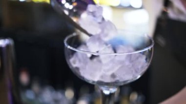 Bir cam buz koyarak bir genç kadın barmen, yakın çekim