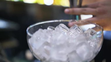 Buz bir kokteyl cam içine votka ekleyerek bir barmen, yakın çekim