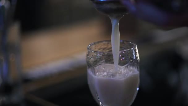 Bartender pouring juice into a glass through a sieve, close up — Stock Video