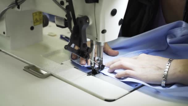 Close up de uma mulher costurando uma camisa em uma fábrica — Vídeo de Stock