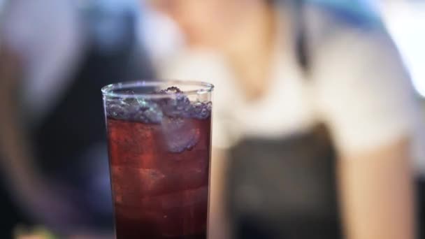 Bartender putting an olive and two straws into a cocktail — Stock Video