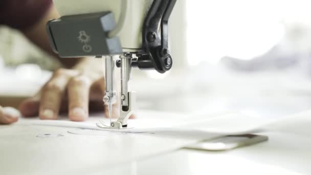 Mujer cosiendo una camisa blanca en una fábrica — Vídeos de Stock