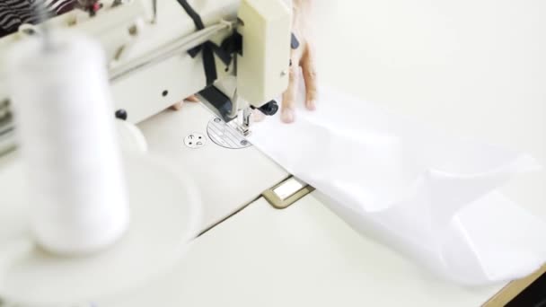Vista dall'alto di una donna che cuce una camicia blu e bianca in una fabbrica — Video Stock