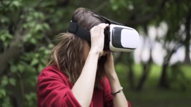 Kırmızılı Vr giyen kadın bir park, yan görünüm gözlük