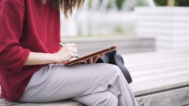 Close up de uma menina de desenho vermelho em seu tablet com uma caneta especial — Vídeo de Stock