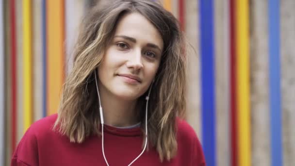 Mujer bastante joven escuchando la música con auriculares y bailando — Vídeo de stock