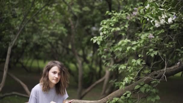 Aşağı eğimli bir parkta güzel bir kitap zevk kız — Stok video