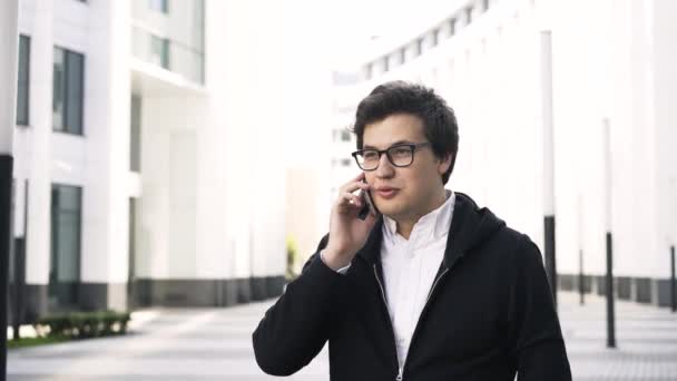 Jonge zakenman op een telefoon in een stad — Stockvideo