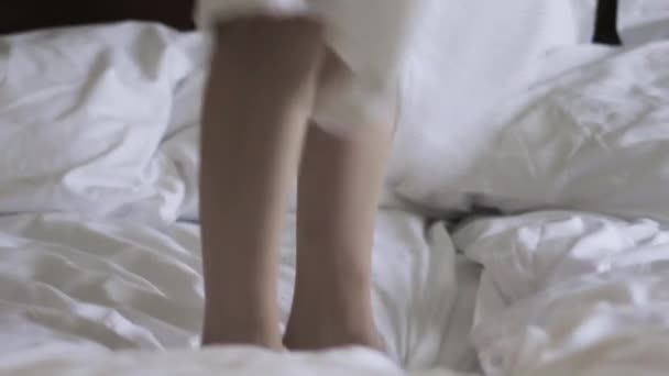 Primer plano de las piernas de la mujer rebotando en una cama, cámara lenta — Vídeos de Stock