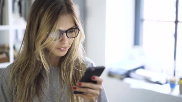 Blonde tiener meisje websurfen met haar smartphone — Stockvideo