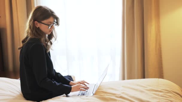 Femme d'affaires en lunettes travaillant dans une chambre d'hôtel — Video