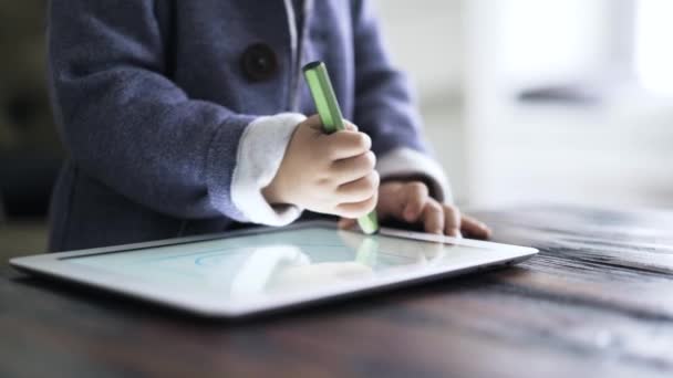 Gros plan des mains de bébé garçon dessinant sur une tablette avec un stylo spécial — Video