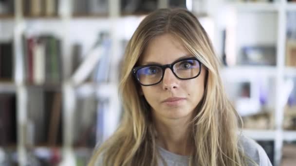 Szőke fiatal nő néz rád szemüveg — Stock videók