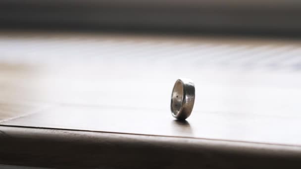 Грубое кольцо, стоящее на ребре на столе — стоковое видео