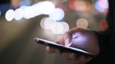 Adam s el bir cep telefonu ekran bir gece road yakınındaki genelinde swiping yakın çekim