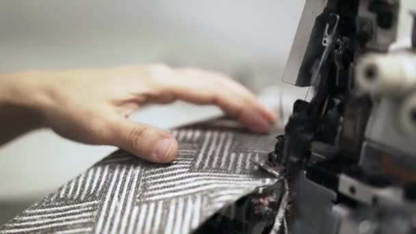 Close-up de uma costureira fazendo uma borda de pano uniforme em uma máquina de costura — Vídeo de Stock