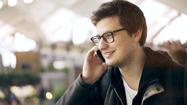 Ung man med en kaffe på telefonen på en bonde s marknad — Stockvideo