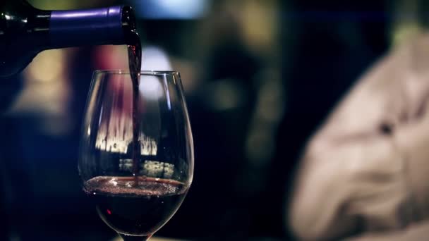Красное вино наливают и кладут на стол — стоковое видео