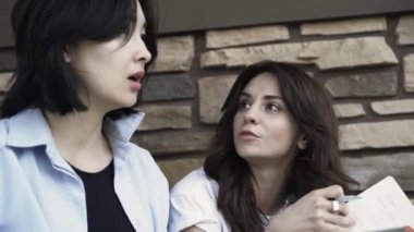 Açık havada çalışan bir dizüstü bilgisayar ile iki genç kadın