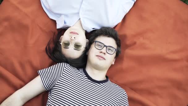 Jeune couple couché sur une couverture sur l'herbe — Video