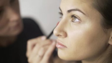 Sarı saçlar kız s yüz tonlama krem uygulamak sanatçı makyaj yan görünüm