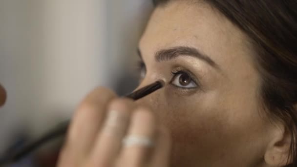 Model with freckles is having her shadows applied, side view — Stock Video