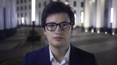 Ciddi genç işadamı kamera, gece city seyir