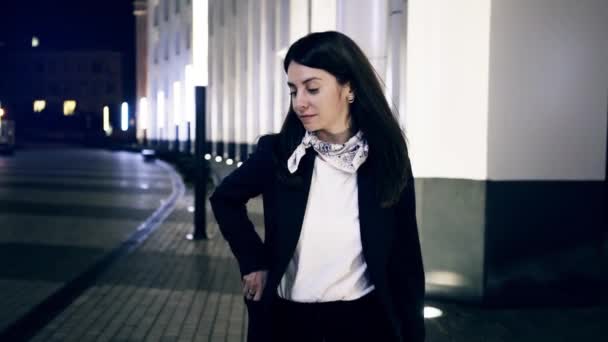 Περπάτημα σε μια πόλη το βράδυ λαμβάνοντας smartphone της και χαμογελώντας επιχειρηματίας — Αρχείο Βίντεο