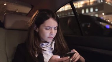 İş kadını, onun smartphone bir arabada bakarken çatık