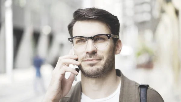 Портрет бізнесмена, який говорить свій смартфон на вулиці і дивиться на камеру . — стокове фото