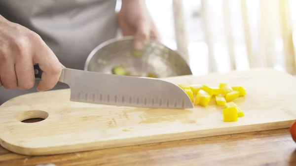 Chief skära röd paprika på en träskiva med en professionell kniv. — Stockfoto