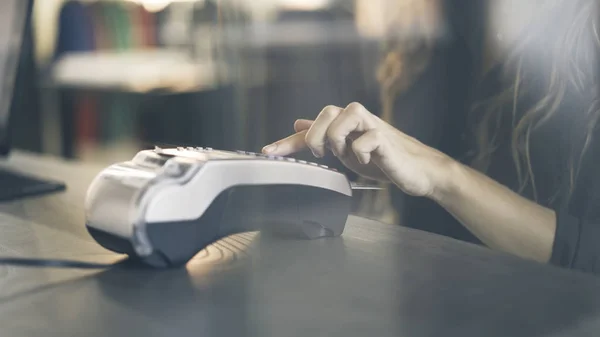 Närbild av kvinna s hand betala med ett kreditkort i en butik. Ange PIN-koden. — Stockfoto