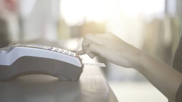 Gros plan de la main de la femme payant avec une carte de crédit dans un magasin . — Photo