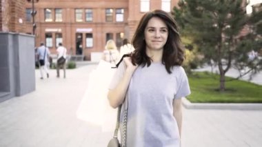 Gülümseyen bir arkadaşına yaz sokak sallayarak dükkandan yürüyüş koyu saçlı kadın