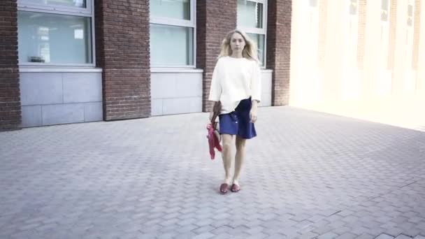 Femme blonde sérieuse traversant une rue — Video