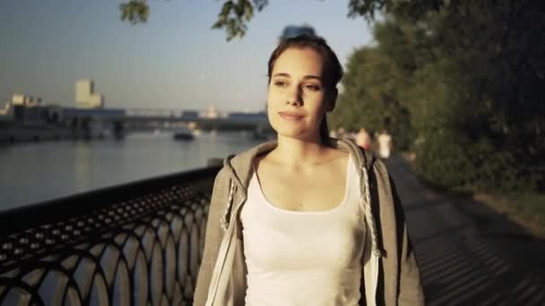 Glimlachend jonge vrouw in een sportkleding wandelen in Moskou stad straat — Stockvideo